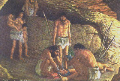 Painting of early people in a rocky cave, some standing with spears and others crouched low near the ground