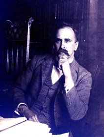 Portrait of Sir William Osler, a man with a moustache and hand raised to his chin, in black and white